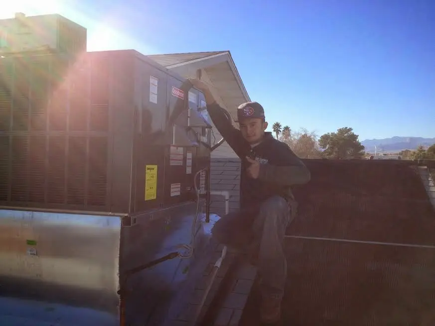 HVAC technician performing Boiler Repair on a rooftop unit in Monroe